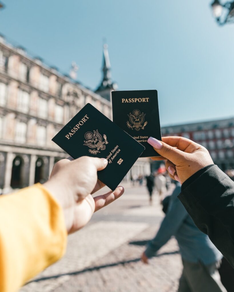 BlockAtlas | Anonymous tourists showing US passports on street on sunny day